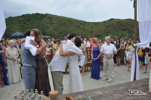 Abraço apertado nos amigos, padrinhos e noivos durante a cerimônia de casamento na Praia Grande, na Ilha do Mel, no litoral do Paraná